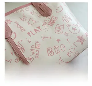 Detailed macro view of graffiti print textures and pink stitching on the underarm tote bag