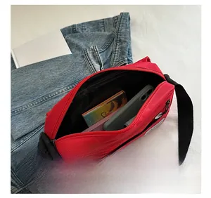 Detail view showing large storage capacity of the red canvas oxford crossbody bag