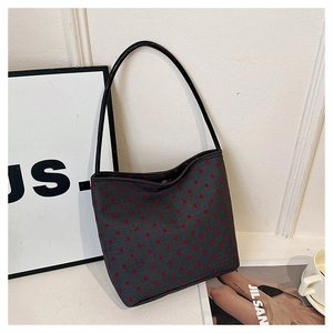 Detail of grey shoulder bag with red heart patterns and slim black leather strap