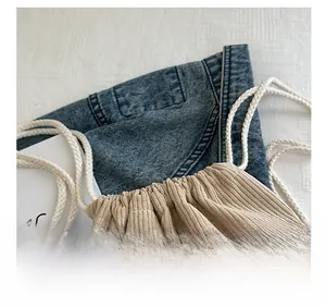 Detail of comfortable cotton braided drawstring straps on beige corduroy backpack