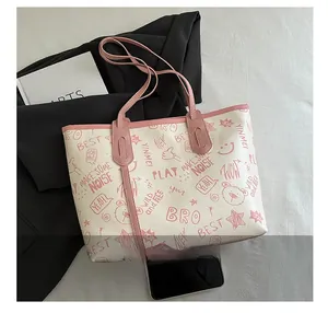 Close-up of graffiti tote bag showing pink contrast straps and cute cartoon bear prints