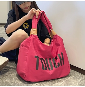 Dettaglio della borsa tote in nylon rosa con scritta TOUCH e inserti in pelle marrone