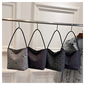Detail shot of canvas shoulder bags featuring polka dots and star patterns on a rack