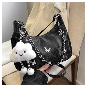 Detail of black wrinkled hobo bag with silver butterfly charms and cloud pendant
