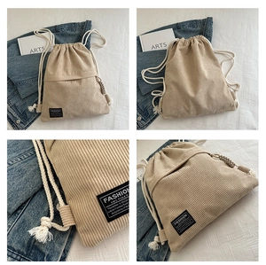 Detailed views of beige corduroy drawstring backpack with cotton ropes and tassel detail