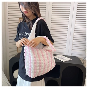 Detail of pink and white striped bubble tote bag with pleated texture and shoulder strap