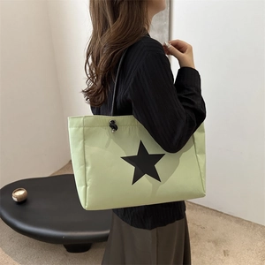 Minimalist light green tote bag with black star print and elegant beaded shoulder straps