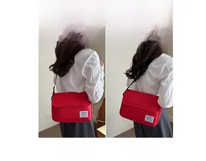 Detail of red oxford fabric messenger bag with adjustable strap and fashion label