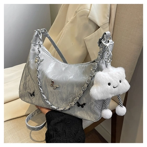 Detail of silver metallic tote bag with butterfly charms and fluffy cloud keychain