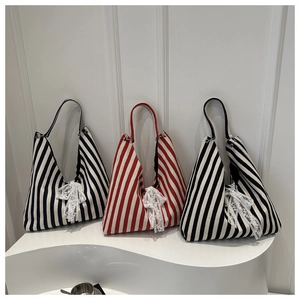 Tres bolsos de lona a rayas azules, rojas y negras con delicados lazos de encaje blanco