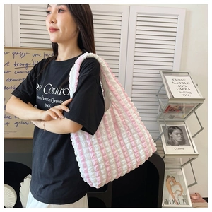 Detailed texture of pink and white striped bubble fabric tote bag on a shoulder