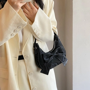 Chic black patent leather crescent handbag with large bow decoration for elegant ladies