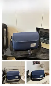 Detail view of the durable blue Oxford cloth messenger bag with adjustable black strap
