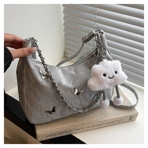 Silver-grey pleated tote bag featuring metallic butterfly charms and a fuzzy cloud pendant