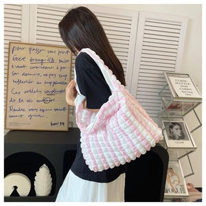 Pink and white striped tote bag with bubble texture shown on a female model's shoulder