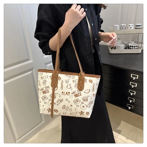 Detail of white tote bag with brown doodle patterns and stylish leather shoulder straps