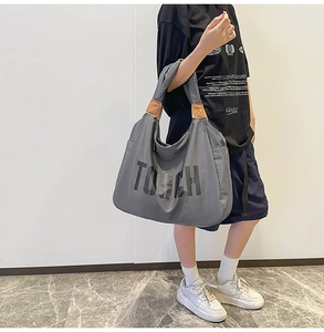 Dettaglio borsa shopper grigia in nylon con scritta nera e inserti in pelle