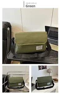 Detail view of the green Oxford fabric messenger bag with adjustable black nylon strap