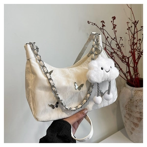 Detail of white butterfly hobo bag with silver chain and cute cloud plush pendant charm