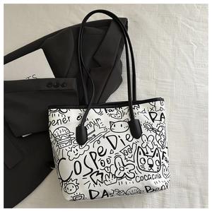 Close-up of artistic graffiti patterns on a white canvas tote bag with black handles