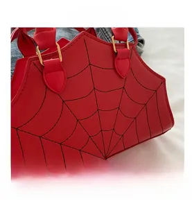 Close-up of red leather bag with black spider web stitching and golden metal rings