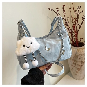Detail of light blue hobo bag featuring silver butterfly chain and cloud plush charm decoration