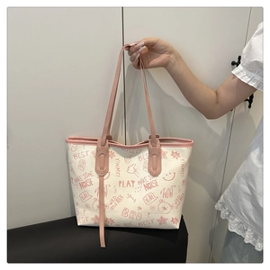Detail of canvas tote bag featuring pink graffiti print and slender shoulder straps