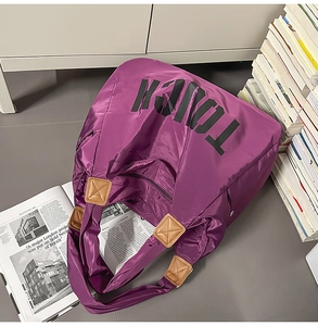 Dettaglio della borsa tote in nylon viola con scritta TOUCH nera e finiture in ecopelle