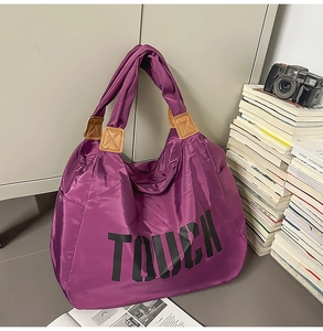 Dettaglio della grande borsa tote in nylon viola con scritta TOUCH in nero