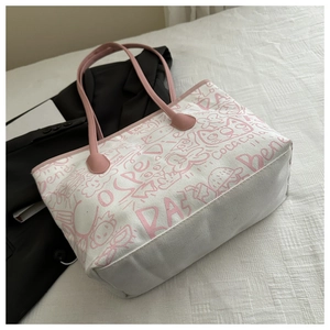 Close-up of graffiti canvas tote bag showing pink printed patterns on white fabric
