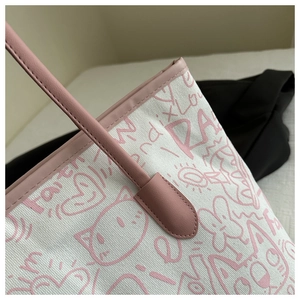 Detail shot of white canvas tote bag with pink hand-drawn graffiti and faux leather straps