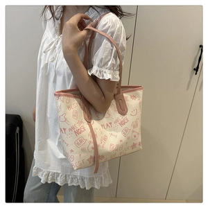 Detail of canvas tote bag with pink graffiti prints worn by a model in a home setting