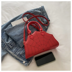 Close-up of red PU leather bag featuring unique black spider web embroidery detail