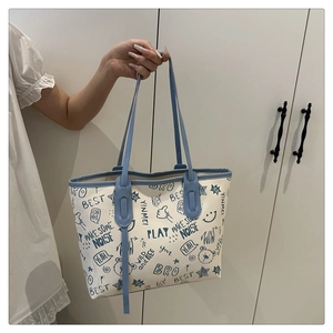 Detail view of blue and white tote bag featuring artistic graffiti lettering and bear prints
