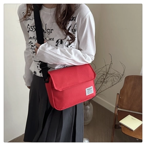 Minimalist red oxford cloth crossbody bag with fashion label and adjustable black strap