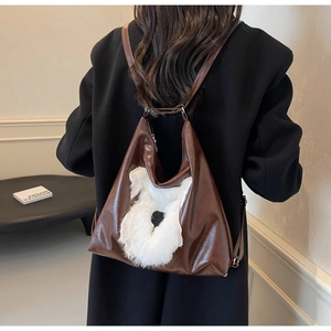 Sac à dos en cuir marron avec motif de chien schnauzer en peluche porté par un mannequin