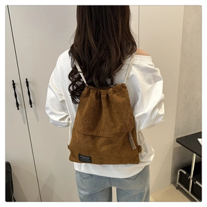 Brown corduroy drawstring backpack with white rope straps on model back view