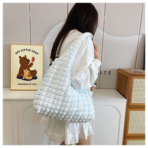 Detail view of the pleated blue and white plaid texture on the stylish shoulder tote bag