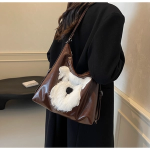 Détail du sac cabas en similicuir marron avec écusson de chien en peluche blanche et bandoulière