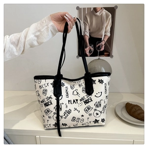 Detail of artistic graffiti patterns on off-white tote bag with black shoulder strap