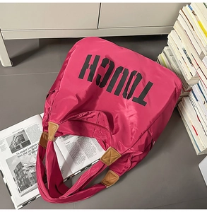 Dettaglio della borsa tote rosa con scritta TOUCH e finiture in pelle marrone moda
