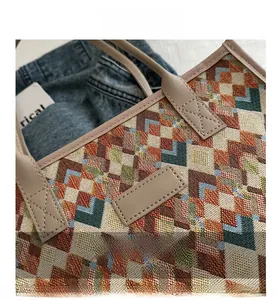 Macro del tessuto jacquard vintage e del bordo in pelle con cucitura a X sulla borsa