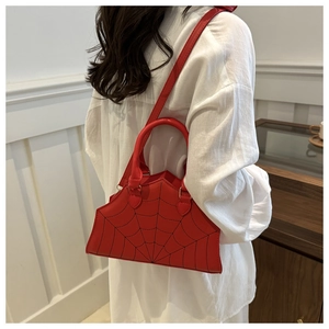 Detail shot of a red spider web embroidery tote bag with shoulder strap worn by a model