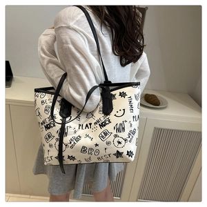 Lifestyle view of large white tote bag with black graffiti bear prints and slim straps