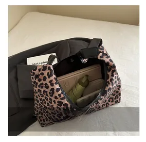 Ruime shopper met luipaardprint toont de grote capaciteit voor laptop en dagelijkse spullen