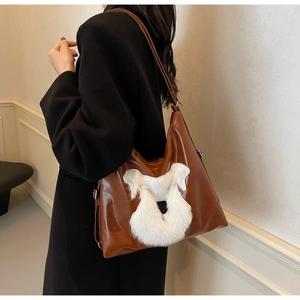 Détail de vue latérale du sac cabas en cuir marron avec patch animal en peluche et lanières