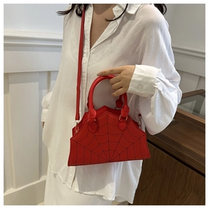 Detail of red spider web embroidered handbag featuring dual handles and PU leather texture