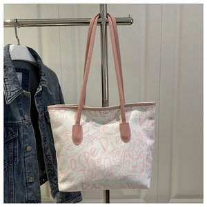 Detail of white canvas tote bag featuring pink graffiti art prints and leather handles