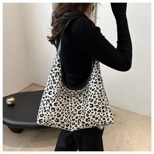 Vue détaillée du grand sac cabas à motif léopard avec des anses en cuir noir robuste