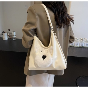Détail du sac cabas en cuir blanc cassé avec écusson chien en peluche et bandoulière réglable